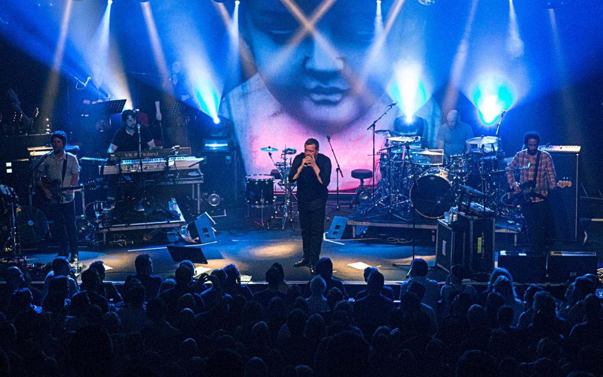 Audience watches a singer against a blue projected backdrop at the Powerstation, Auckland